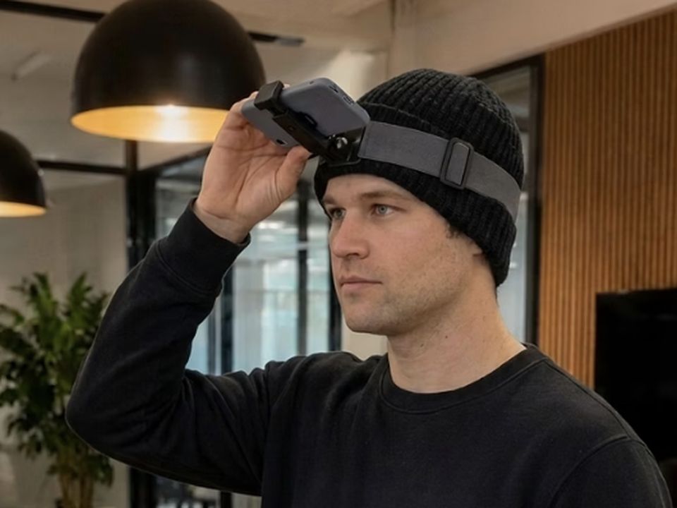 Employee adjusting a head strap holding a phone